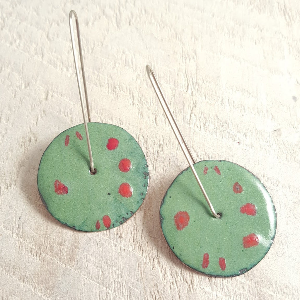 Green enameled copper earrings with red accents.