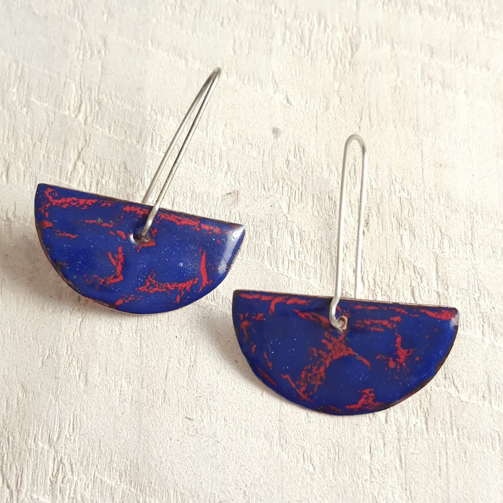 Red enameled copper earring with blue accents.