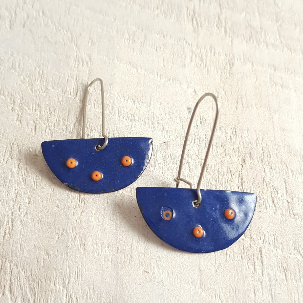 Dark blue enameled copper earring with orange accents.