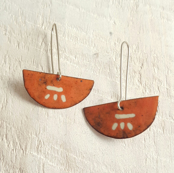 Orange enameled copper earrings with cream accents.