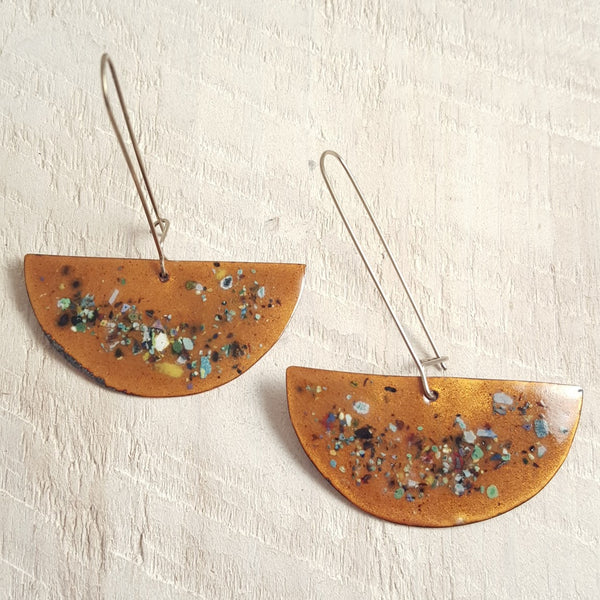 Transparent enameled copper earrings with speckled accents.