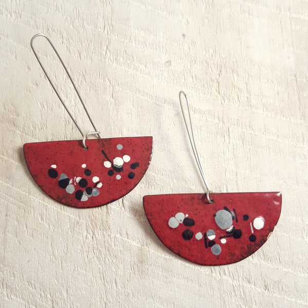 Dark red enameled copper earrings with black, grey, and white accents.