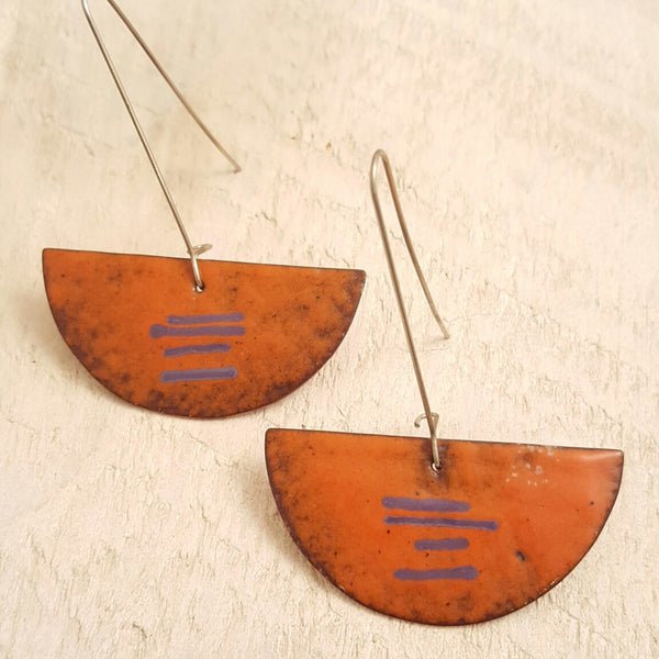 Orange enameled copper earrings with purple accents.