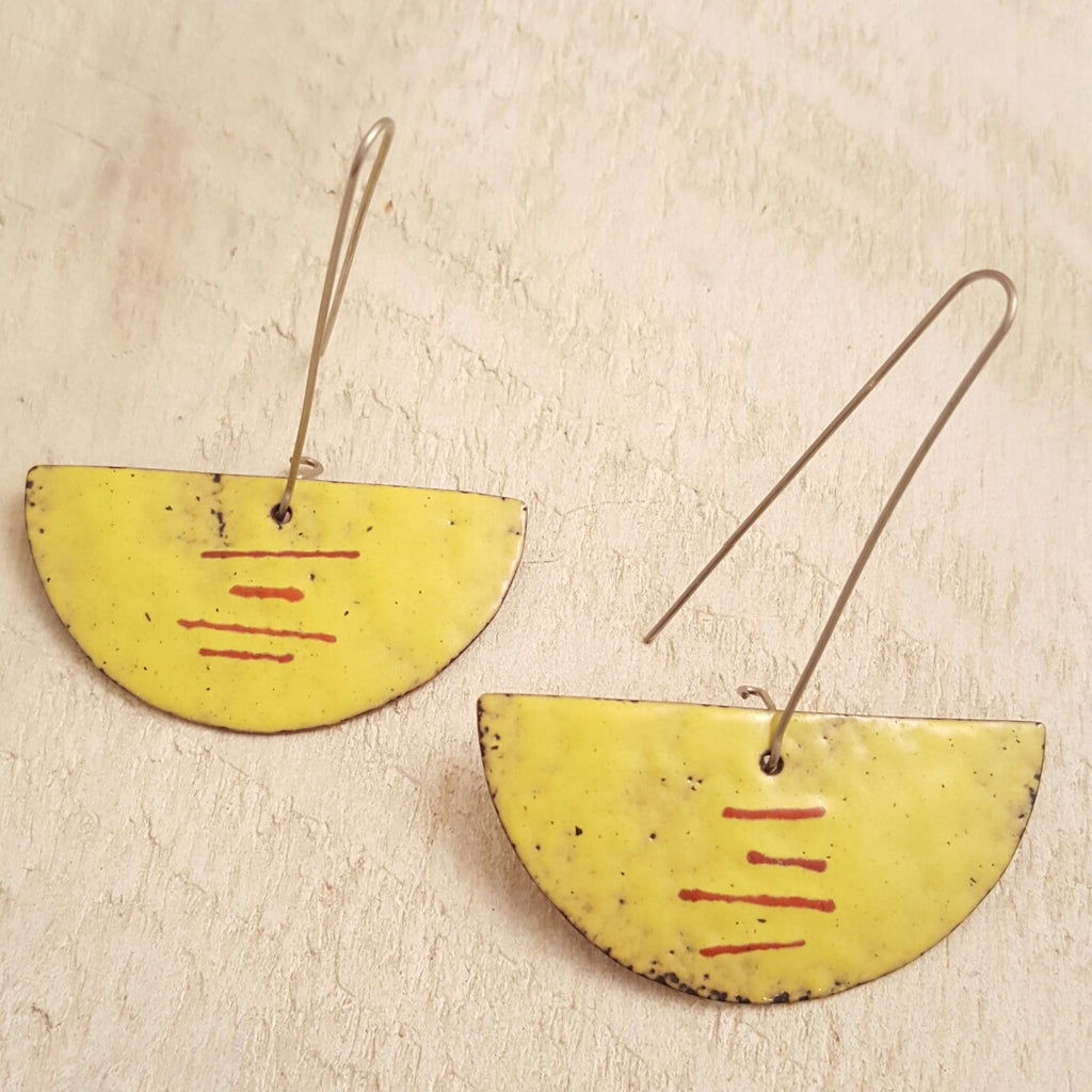 Yellow enameled copper earring with red accents.