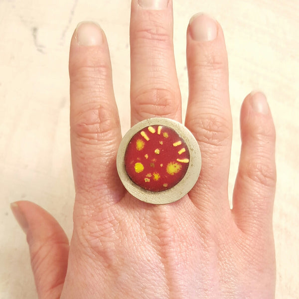 Red enameled copper ring with yellow accents.