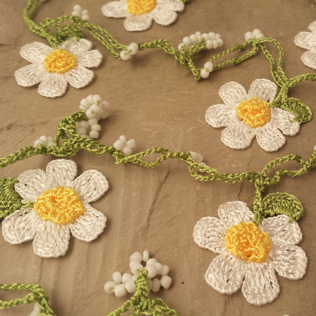 White daisy flowers with yellow center and light green string.