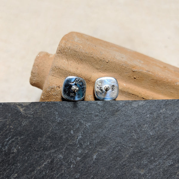backs of stud with artist stamp and silver marker