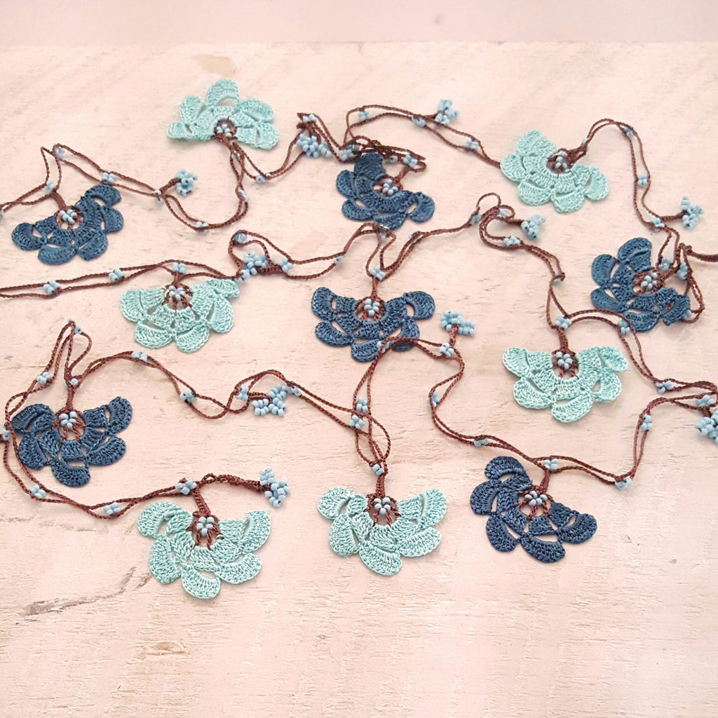 Teal and aqua flowers with brown string.