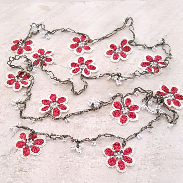 Red flowers with white borders and green string.
